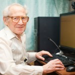 Smiling Senior Man Near Computer